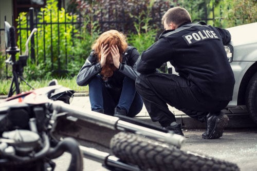 Police officer comforting woman after motorcycle accident