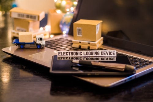 Truck black box tech concept image with laptop, miniature truck and shipping boxes