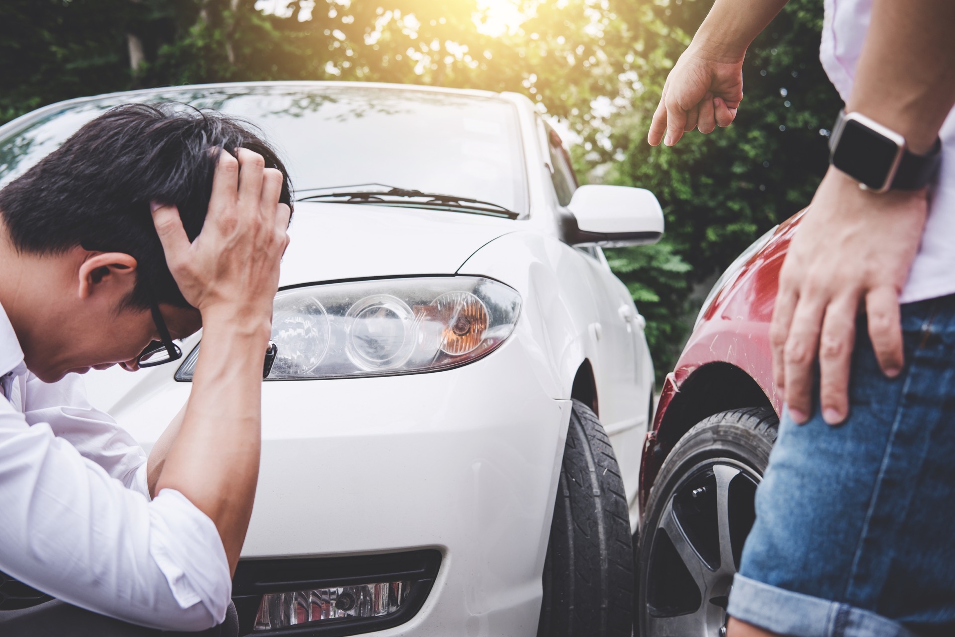 people looking at damage of vehicles after accident
