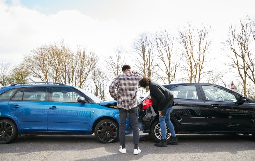 Man And A Woman Inspecting Their Damaged Cars