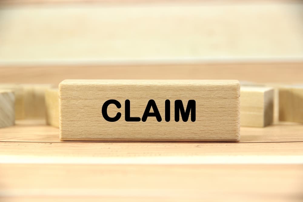 claim wording or text on wood block with wooden background.