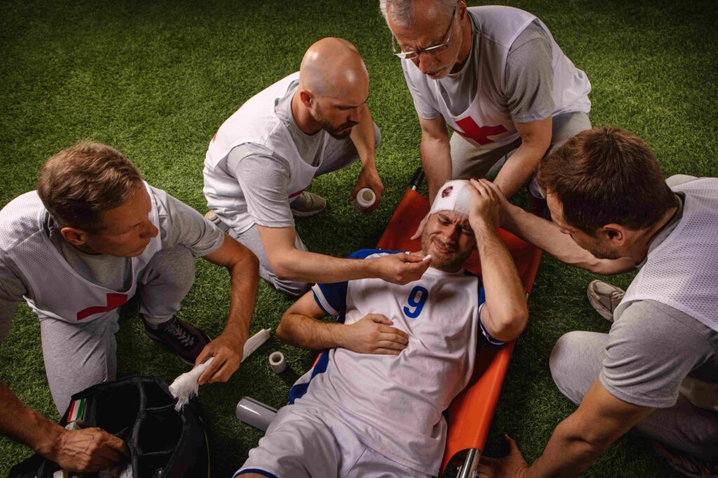 Injured soccer player receiving medical attention on the field after head injury during game.
