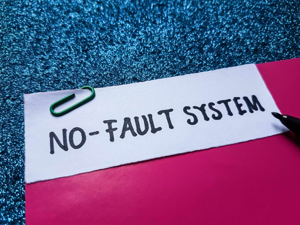 Close-up of note labeled ‘No-Fault System’ on a folder, representing no-fault insurance and accident claims process.