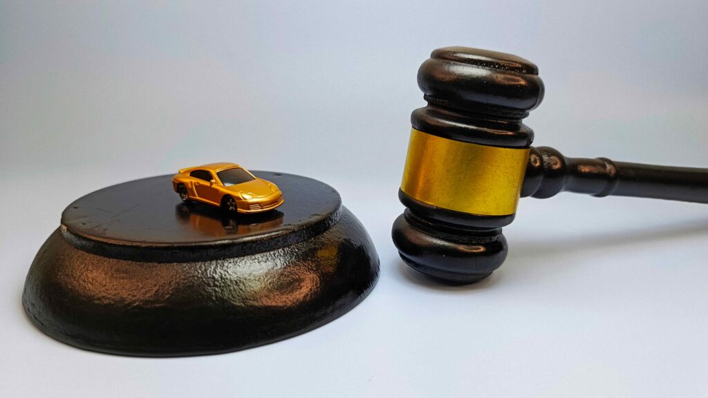 Judge gavel next to a toy car, representing auto accident lawsuit and car insurance legal claims.
