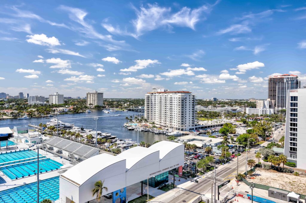 Aerial view of Fort Lauderdale waterfront with marina, high-rise buildings, and city skyline under blue sky. Aerial view of Fort Lauderdale waterfront with marina, high-rise buildings, and city skyline under blue sky.
